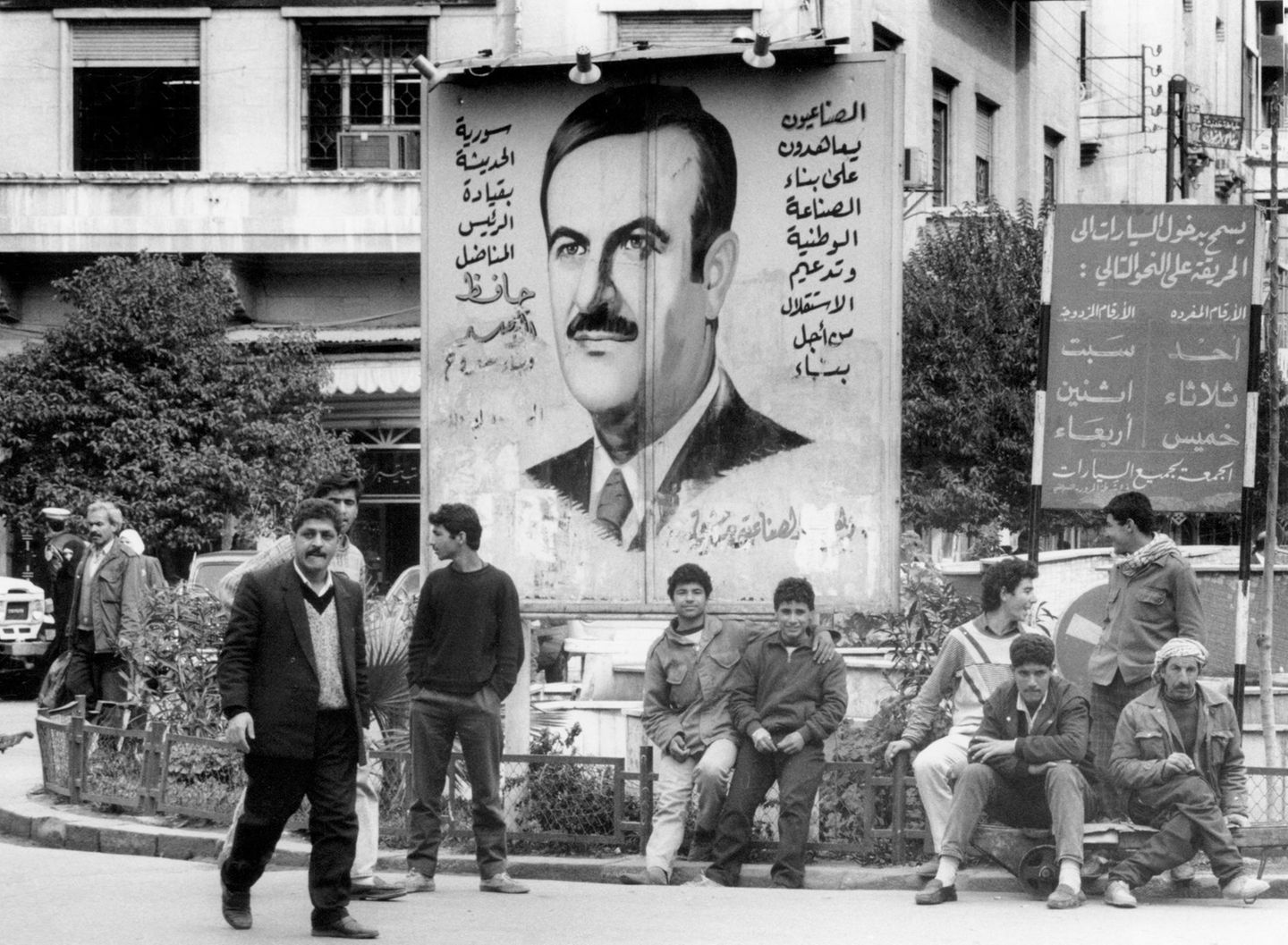 Straßenszene in Syrien mit einem Plakat, das Präsident Hafiz al-Assad zeigt