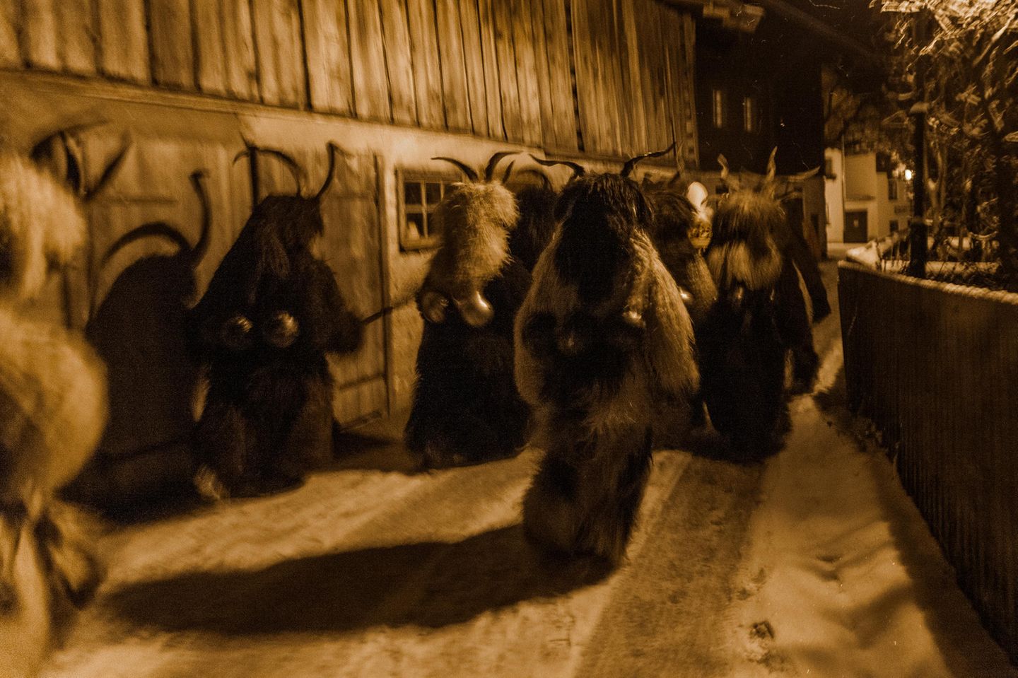 Wie aus einer anderen Zeit muten die zotteligen Gestalten an, die sich in der Dämmerung die vereiste Dorfstraße entlang bewegen und lange bedrohliche Schatten an den Wänden der Stallungen werfen 