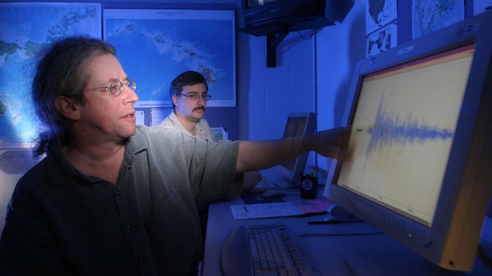 Zwei Wissenschaftler des Pacific Tsunami Warning Center auf Hawaii vor einem Seismographen