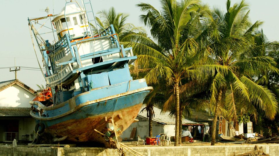 Ein Schiff liegt auf dem Trockenen vor einem Haus im Norden von Sumatra 