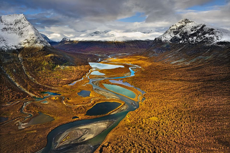 Ein Tal mit Fluss, im Hintergrund Berge