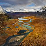 Ein Tal mit Fluss, im Hintergrund Berge