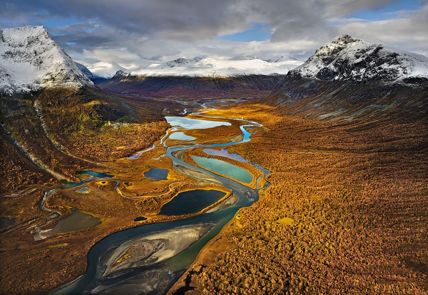 Ein Tal mit Fluss, im Hintergrund Berge