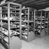 Unzählige Schuhe stehen in mehreren Holzregalen