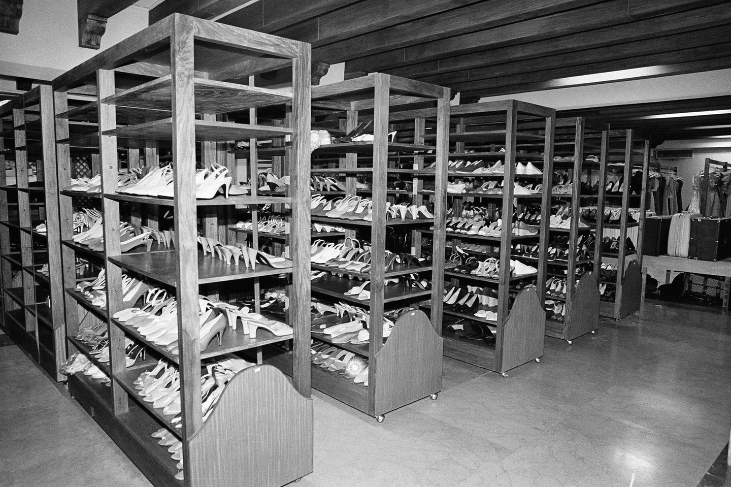 Unzählige Schuhe stehen in mehreren Holzregalen