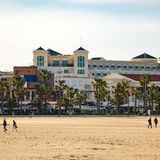 Strandabschnitt mit imposanten Gebäude in warmes Licht gehüllt.