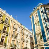 Eine frontal fotografierte, gelbe Hausfassade. Unten im Ladengeschäft gibt es Obst und Gemüse.
