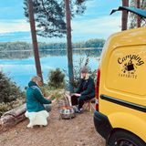 Zwei Frauen wärmen sich am Feuer