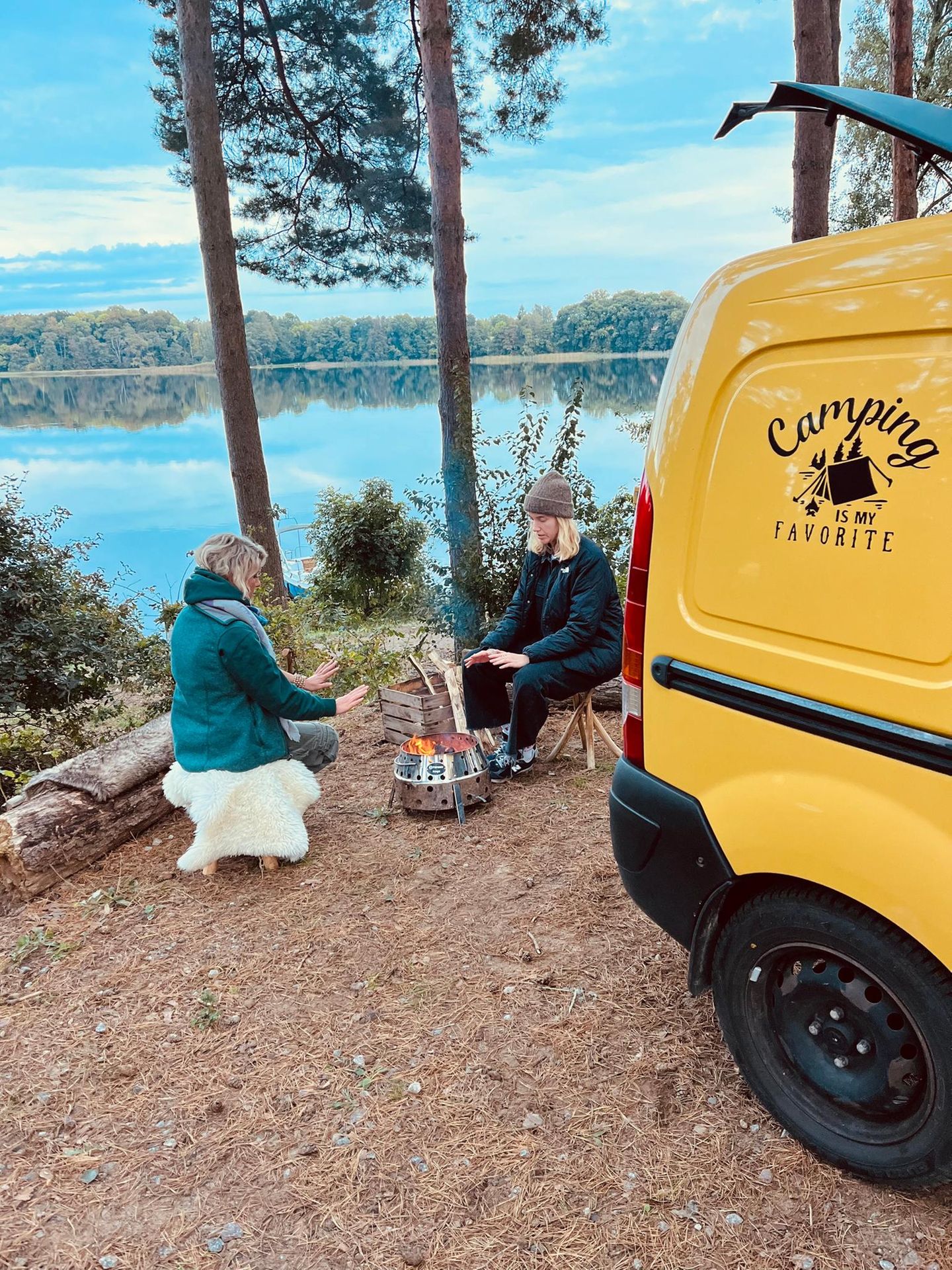 Ahoi Camp Canow, Mecklenburgische Seenplatte Zwei Frauen wärmen sich am Feuer