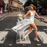 Braut läuft über Zebrastreifen