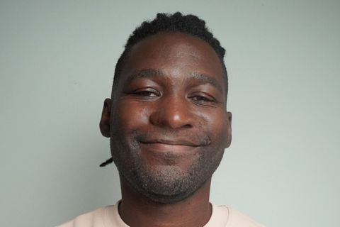 Afrofluencer Stève Hiobi (Dein Bruder Stève) hält seine Faust an die Brust