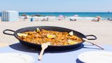 Ein Valencia-Besuch ohne Paella? Undenkbar! Dieses Gericht ist eng mit der Stadt verbunden. Die Paella Valenciana gilt als authentische Paella. Der Reis für das Gericht wird im Albufera-Park angebaut. Dort soll die Paella auch erfunden worden sein. Das Wort selbst stammt aus dem Valencianischen und bedeutet so viel wie "Bratpfanne". In der werden die Hauptzutaten angebraten, darunter meist Huhn und Kaninchen, Ferradura-Bohnen, Garrofó-Bohnen und Tomaten. Es gibt aber auch Varianten mit Fisch oder vegetarische mit Gemüse. 