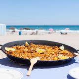Ein Valencia-Besuch ohne Paella? Undenkbar! Dieses Gericht ist eng mit der Stadt verbunden. Die Paella Valenciana gilt als authentische Paella. Der Reis für das Gericht wird im Albufera-Park angebaut. Dort soll die Paella auch erfunden worden sein. Das Wort selbst stammt aus dem Valencianischen und bedeutet so viel wie "Bratpfanne". In der werden die Hauptzutaten angebraten, darunter meist Huhn und Kaninchen, Ferradura-Bohnen, Garrofó-Bohnen und Tomaten. Es gibt aber auch Varianten mit Fisch oder vegetarische mit Gemüse. 