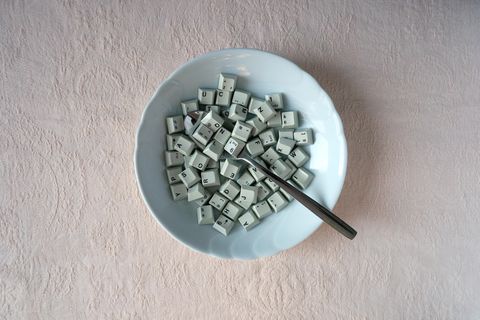 In einem Suppenteller liegen Tasten einer Computer-Tastatur und ein Löffel