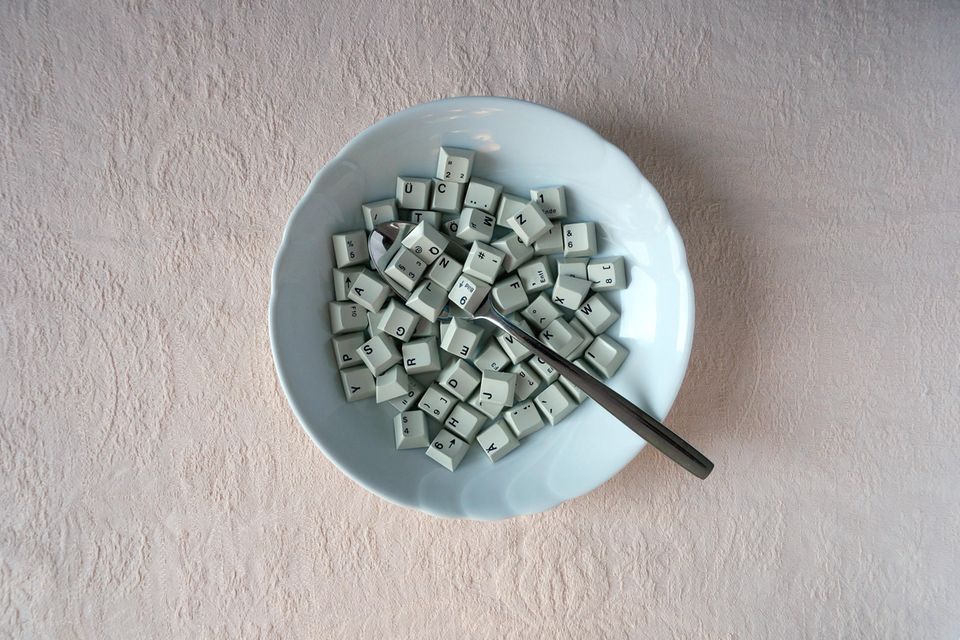 In einem Suppenteller liegen Tasten einer Computer-Tastatur und ein Löffel 1.5048