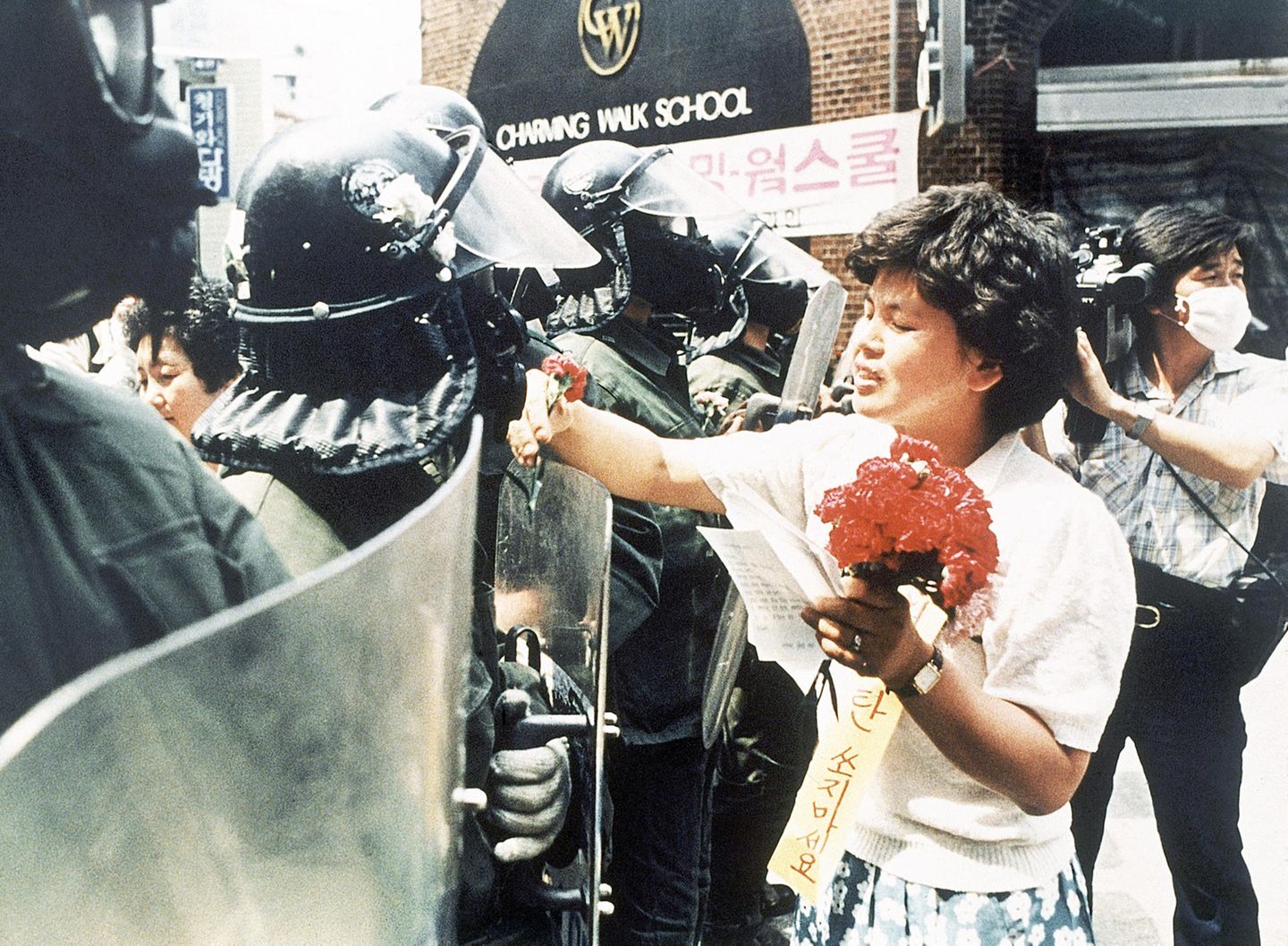 Eine Südkoreanerin übergibt einem Polizisten Blumen