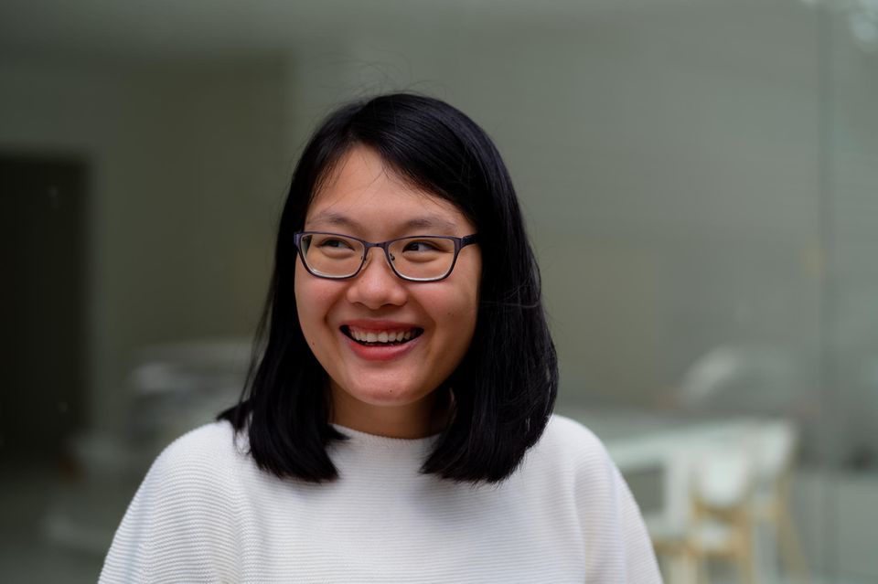 Uyen Ninh lacht und blickt zur Seite vor unscharfem Hintergrund 1.5004