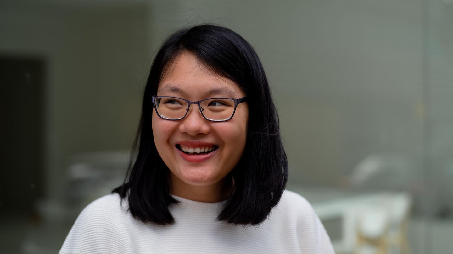 Uyen Ninh lacht und blickt zur Seite vor unscharfem Hintergrund