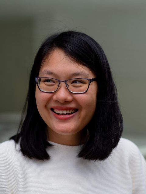 Uyen Ninh lacht und blickt zur Seite vor unscharfem Hintergrund