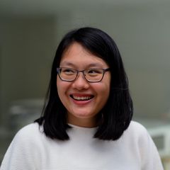 Uyen Ninh lacht und blickt zur Seite vor unscharfem Hintergrund