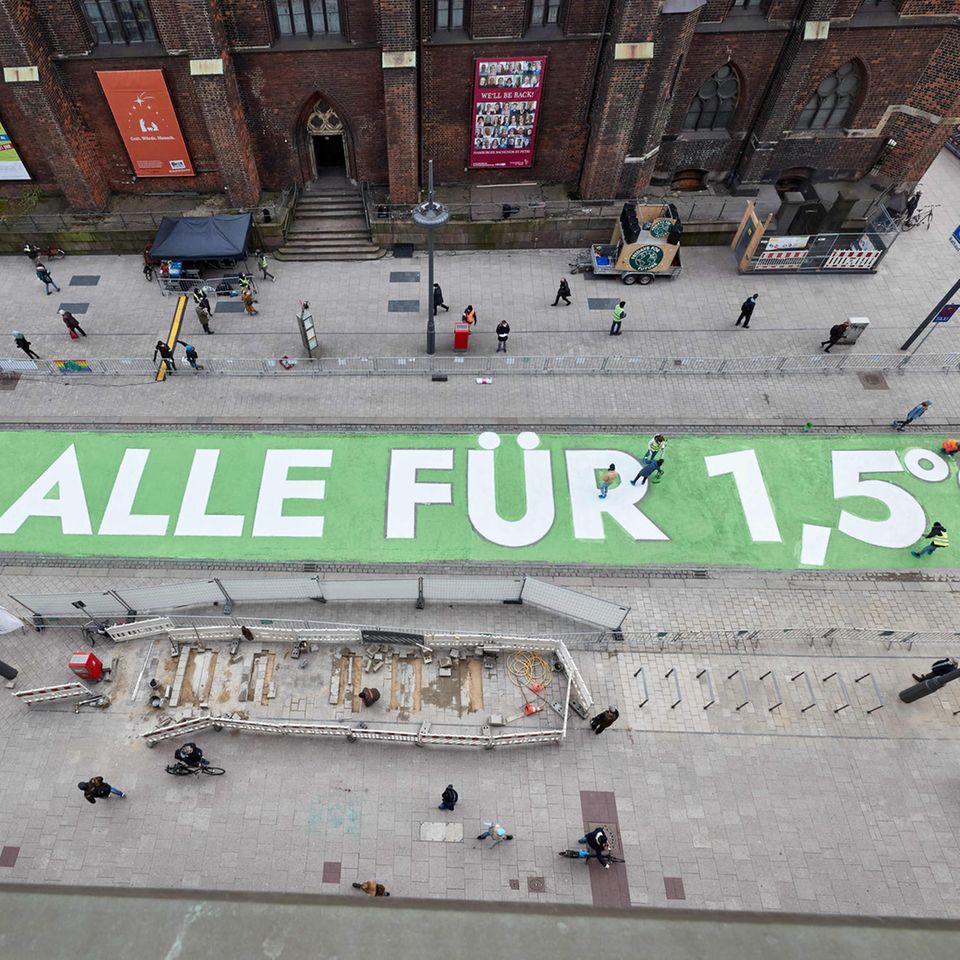 Zum siebten globalen Klimastreik im März 2021 malten Aktivistinnen und Aktivisten der Gruppe Fridays for Future einen Appell für die Einhaltung des 1,5-Grad-Ziels auf eine Straße in der Hamburger Innenstadt