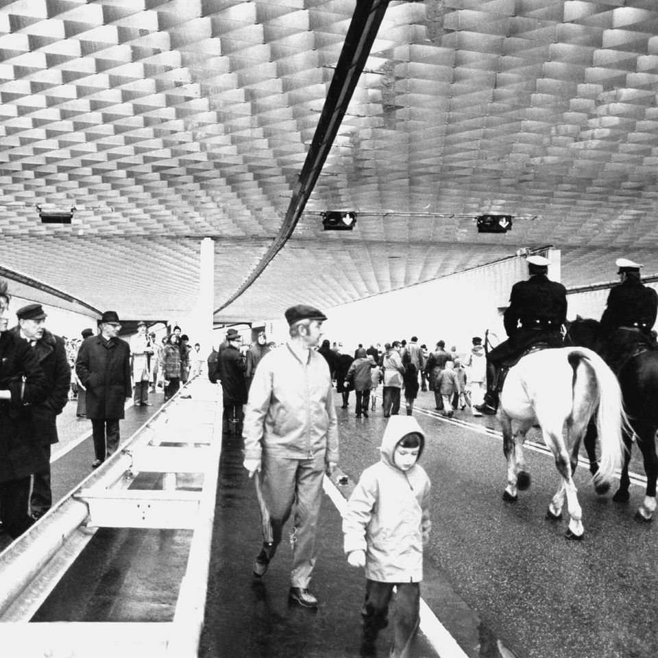 Viele Fußgänger und zwei Polizisten auf Pferden durchwandern den neu eröffneten Elbtunnel