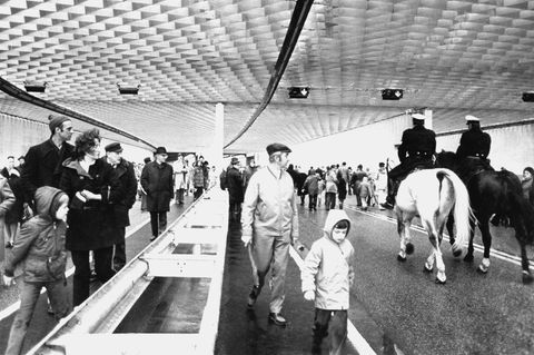 Viele Fußgänger und zwei Polizisten auf Pferden durchwandern den neu eröffneten Elbtunnel