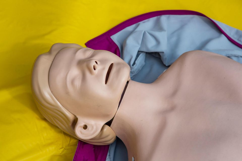 Erste-Hilfe-Puppe auf einer gelben Folie Erste-Hilfe-Puppe auf einer gelben Folie