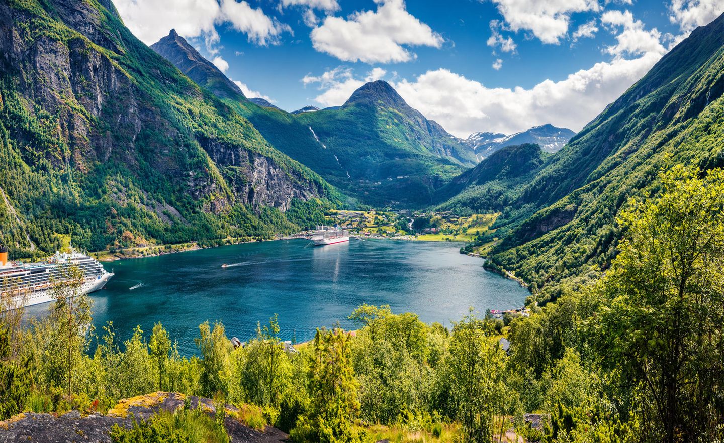 der Fjord erleuchtet im Sonnenschein, umgeben von Bergen.