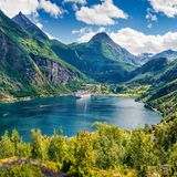der Fjord erleuchtet im Sonnenschein, umgeben von Bergen.
