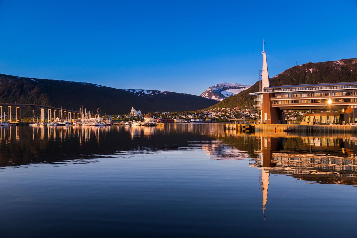 die sich im Wasser spiegelnde Stadt, eingehüllt im warmen Licht der Mitternachtssonne