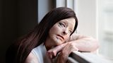 Frau sitzt am Fenster