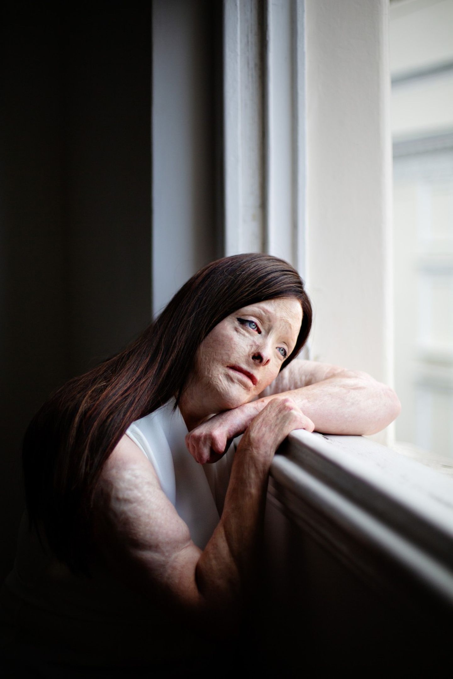Frau sitzt am Fenster