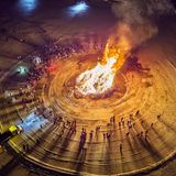 Menschen stehen um Lagerfeuer