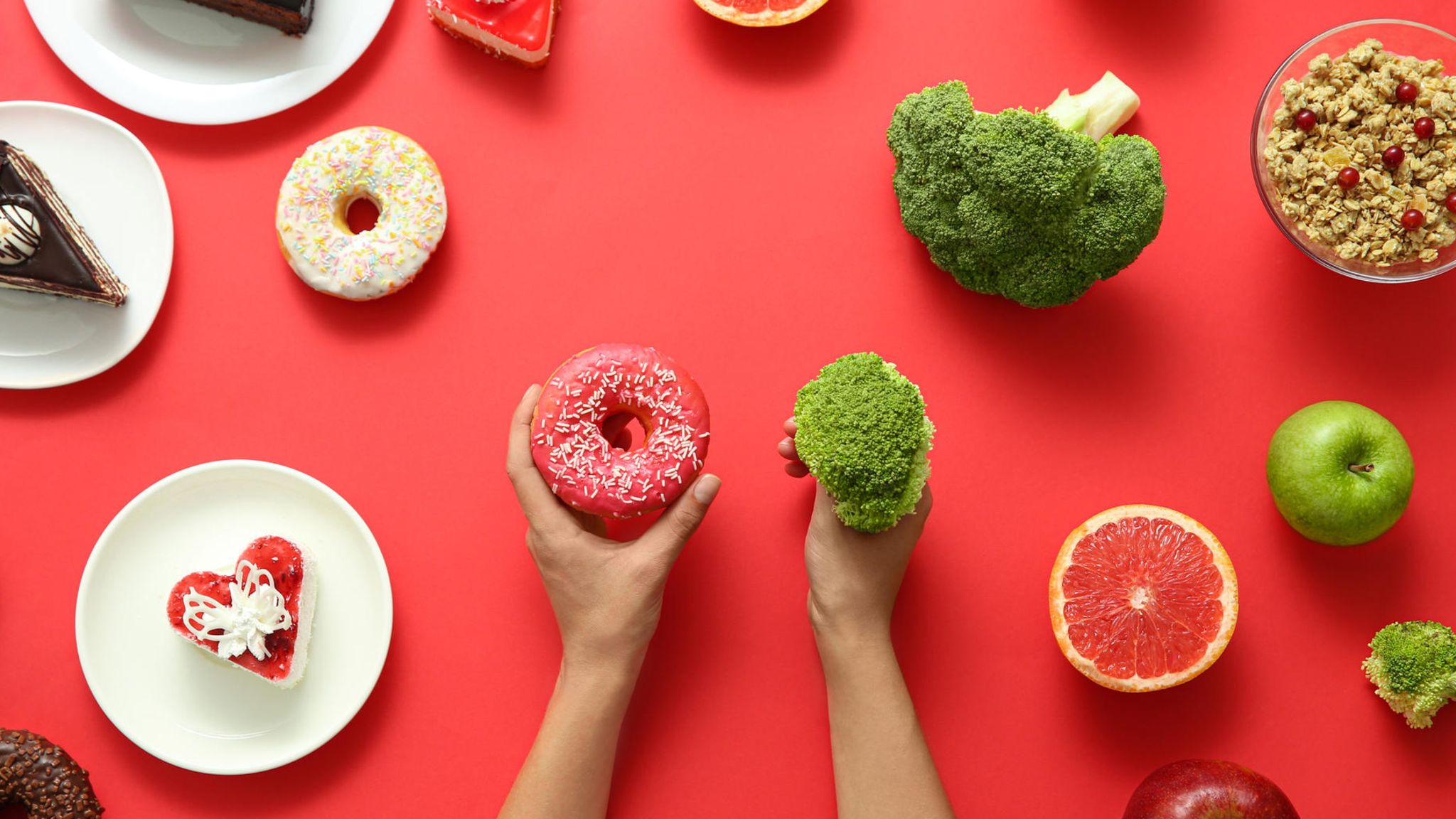 links liegen ungesunde Lebensmittel, rechts gesunde, je eins davon wird in der Hand gehalten