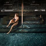 Frau sitzt auf einer Treppe am Pool im Hvidbjerg Strand Camping