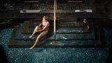Frau sitzt auf einer Treppe am Pool im Hvidbjerg Strand Camping