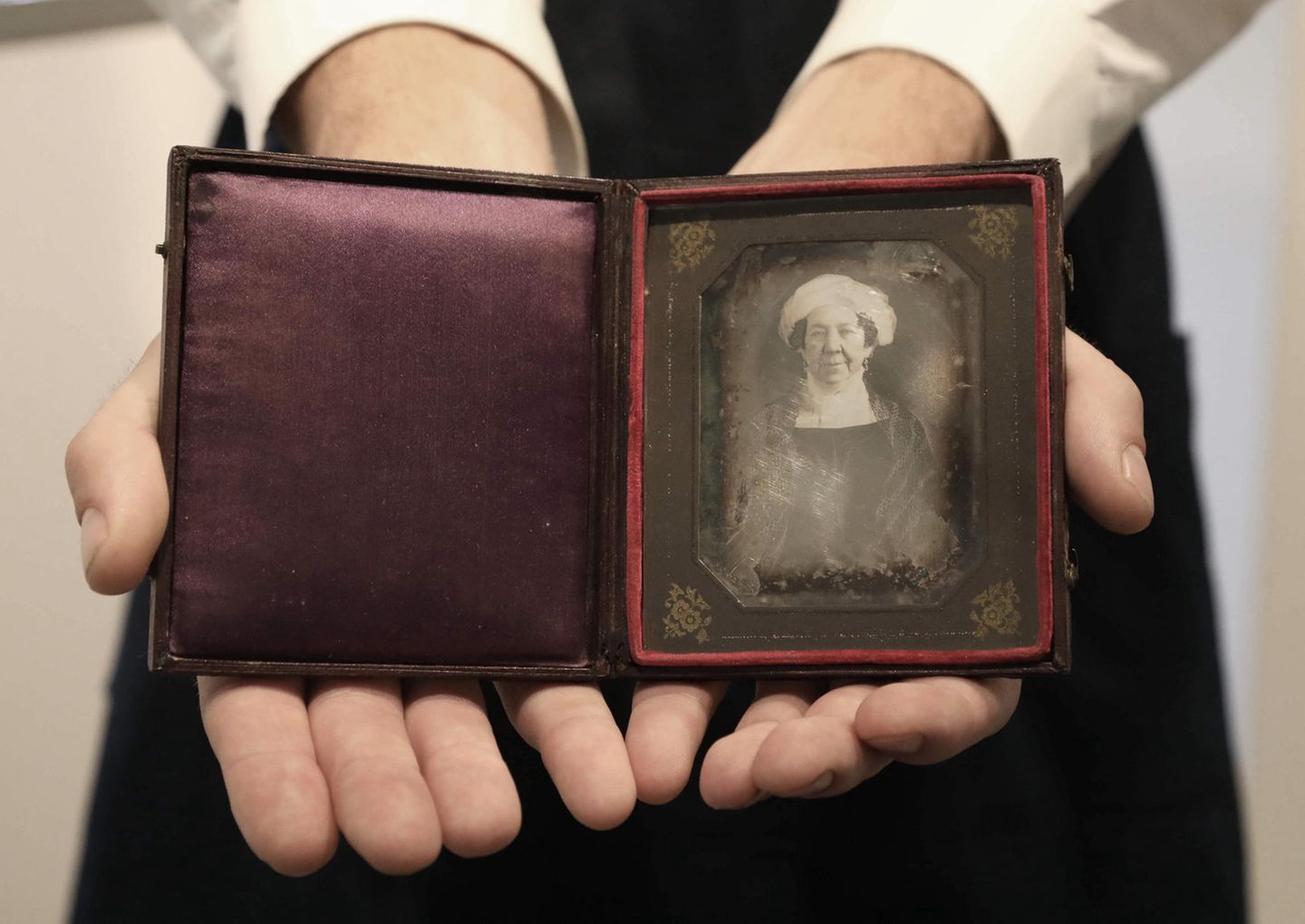 Zwei Hände halten eine Etui mit dem Foto von Dolley Madison