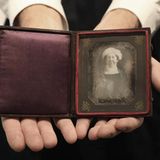 Zwei Hände halten eine Etui mit dem Foto von Dolley Madison