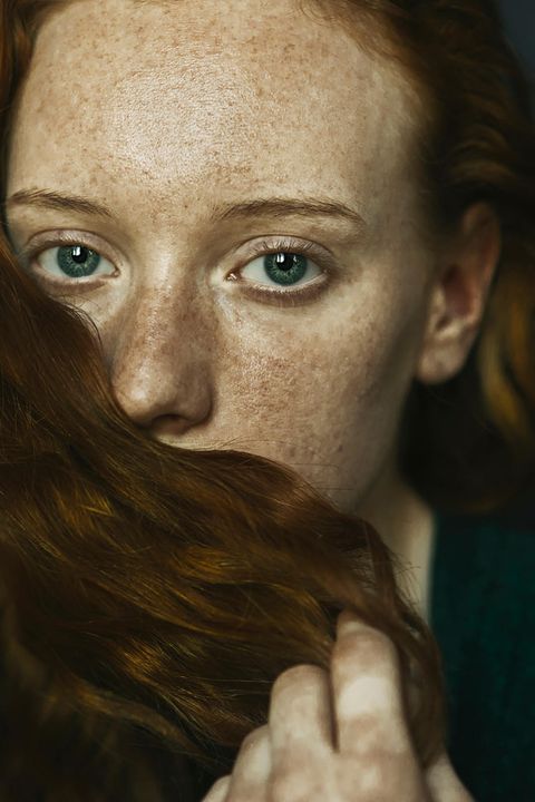 Frau bedeckt ihren Mund mit einer Haarsträhne