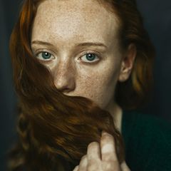Frau bedeckt ihren Mund mit einer Haarsträhne