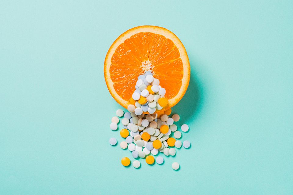 Aufgeschnittene Orange mit Tabletten im Vordergrund 1.4222