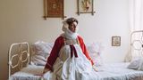 Frau in griechischer Tracht auf Bett