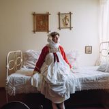 Frau in griechischer Tracht auf Bett