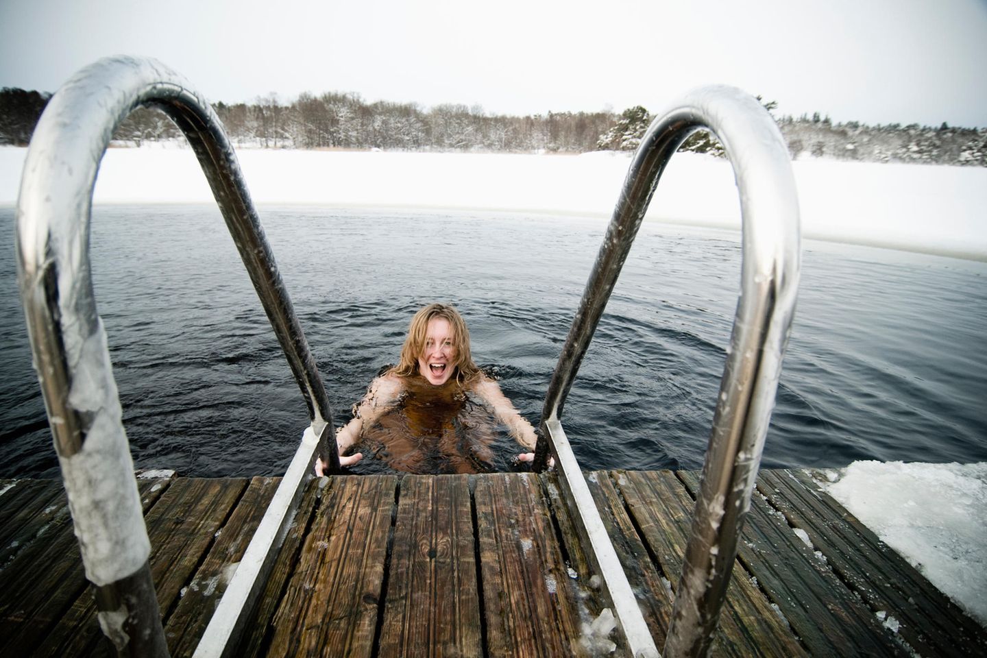 Winterbaden und Sauna: Natur genießen in Hellasgården Frau taucht im Wasser ab, Winterstimmung