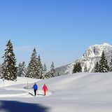 Wanderndes Paar in verschneiter Alpenlandschaft