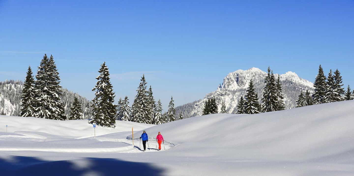 Wanderndes Paar in verschneiter Alpenlandschaft