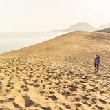 Frau läuft durch die Tottori Sanddünen in Japan