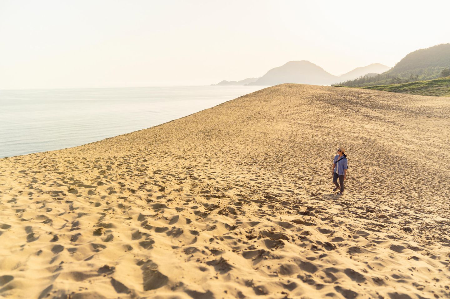Frau läuft durch die Tottori Sanddünen in Japan