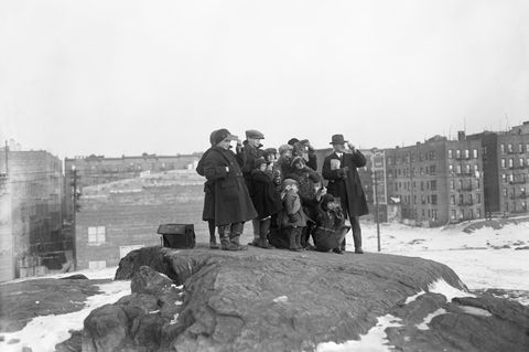 Gruppe von Menschen steht auf Felsen und blickt in den Himmel